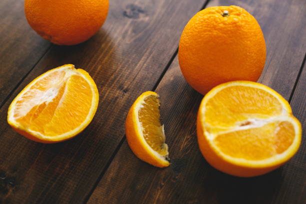 oranges mûres tranchées sur une table en bois. manger sainement - food wood vibrant color close up photos et images de collection