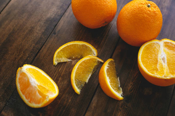 les oranges se trouvent sur une table en bois naturel. manger sainement - food wood vibrant color close up photos et images de collection