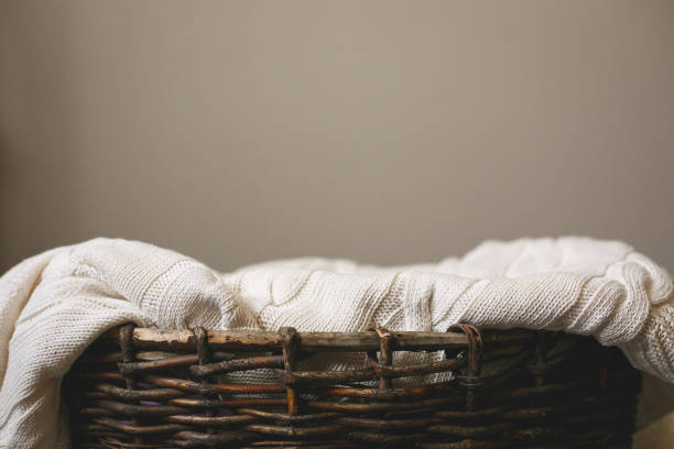 istock Wicker basket with a beautiful white knitted cloth on gray background 1192711252