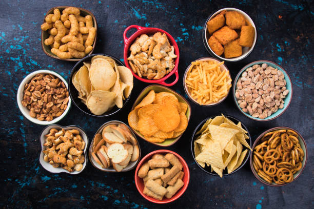 Salty snacks served in bowls Salty snack including peanuts, potato chips and pretzels served as party food in bowls savory food stock pictures, royalty-free photos & images