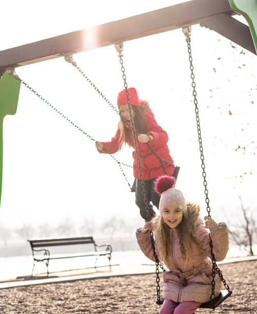 istock Girls using a swing outdoors 1192712490
