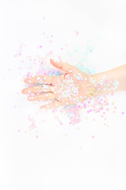 istock Pearl pastel confetti sparkles with woman hand 1192714039