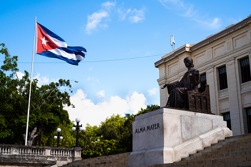 Havana, Cuba - 02 July 2019: University of Havana with Alma Mater sculpture and Cuban Flag, in the Vedado district of the city