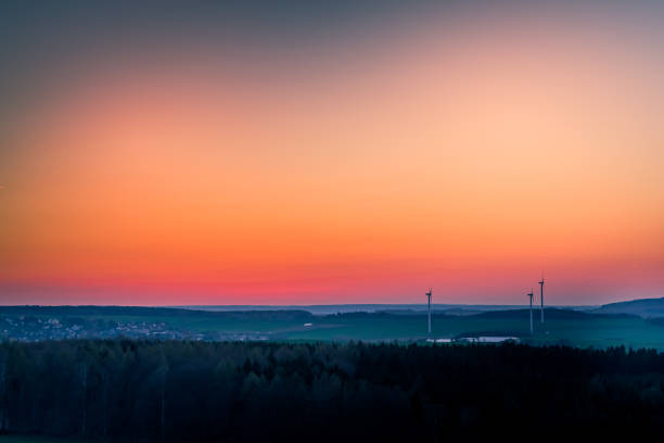 istock wind turbines in the orange sunset 1192717946