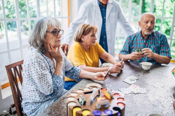istock Group of seniors playing cards together 1192719196