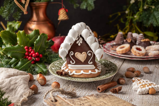 lebkuchenhaus mit weihnachtsplätzchen im hintergrund - cookie heart shape shortbread christmas stock-fotos und bilder