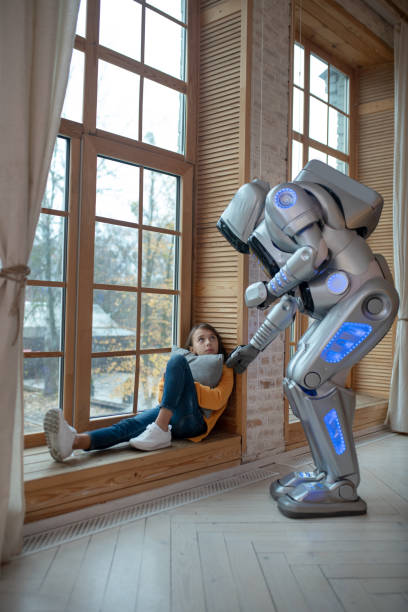 istock Cute teen sitting at the window with sad expression 1192723071