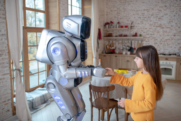 istock Robot and a cute girl standing in the kitchen 1192723115