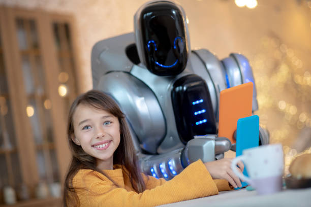 istock Robot with tablet and a smiling girl sitting at the kitchen 1192723192