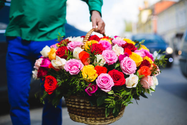 entrega de flores. hombre sosteniendo un gran ramo de hermosas flores en una cesta de mimbre - wicker basket store gift shop fotografías e imágenes de stock