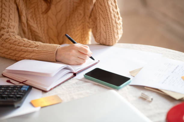 istock Dark-haired woman in knitted sweater writing in her notebook 1192726855