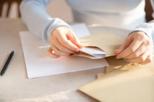 Busy with post. Woman in grey outfit sitting at the table