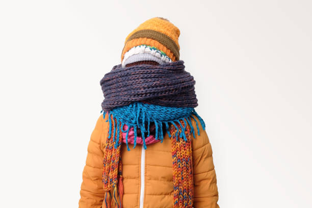 Handsome caucasian funny man hiding face in several hats and scarfs. Handsome caucasian funny man hiding face in several hats and scarfs. Winter fashion. stressed man funny stock pictures, royalty-free photos & images