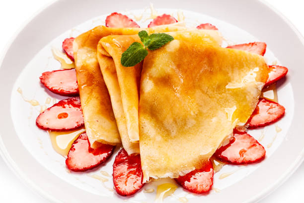 istock Crepes with strawberries and cream on white background 1192728623