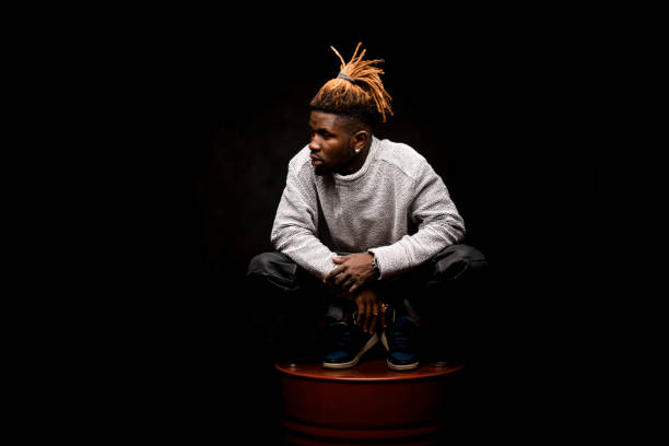 istock Afro american guy squatting on a barrel 1192728801