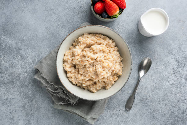 gesundes frühstück brei hafer oder haferflocken in der schüssel - oatmeal porridge oat raisin stock-fotos und bilder