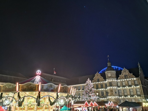 Düsseldorf Christmas Market close to town hall at night time with beautiful lights, carousel and ferris wheel