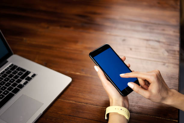istock Mockup image of a woman using smartphone with blank screen on wooden table. 1192730727