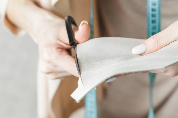 istock Woman measuring and cutting leather in a workshop 1192733015