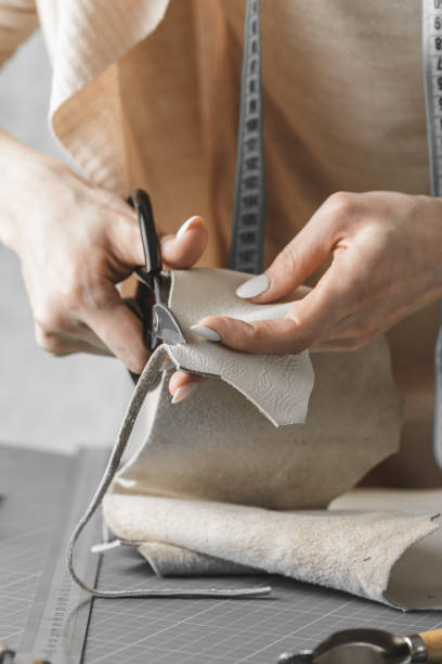 istock Woman measuring and cutting leather in a workshop 1192733173