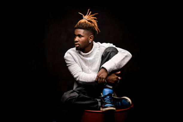 istock Black guy with blonde dreadlocks posing squatting on the oil barrel 1192735485