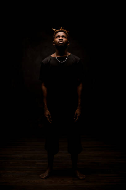 istock Black man with blonde dreadlocks posing in the dark outfit looking up 1192735560