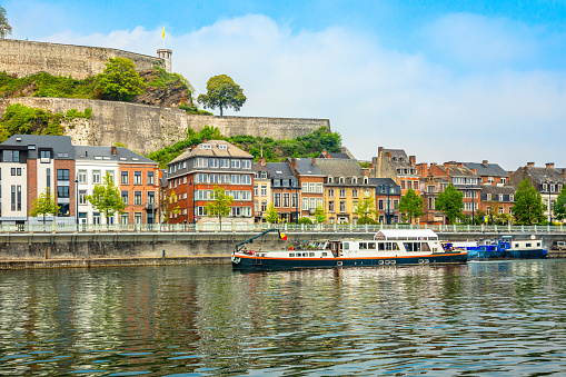 Meuse river with passenger boats and Citadel of Namur fortress on the hill, Namur, Wallonia, Belgium