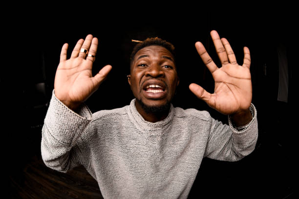 istock Fish-eye photo black man with blonde dreadlocks posing looking at camera showing palms 1192736213