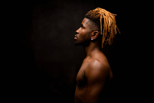 istock Side view naked black guy with blonde dreadlocks posing in the studio 1192736275
