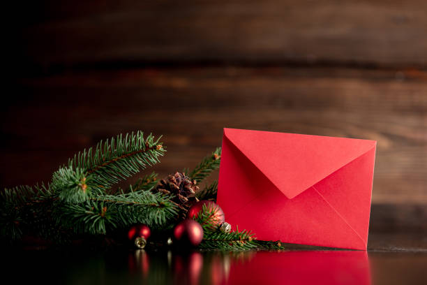 Red envelope and Christmas tree decoration on wooden table