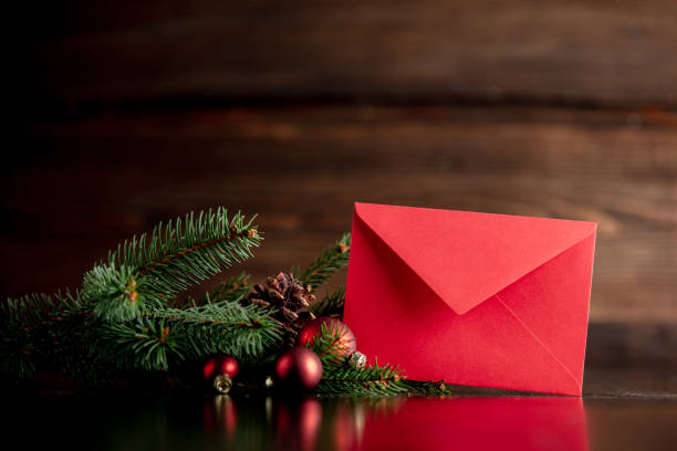 Red envelope and Christmas tree decoration on wooden table stock photo