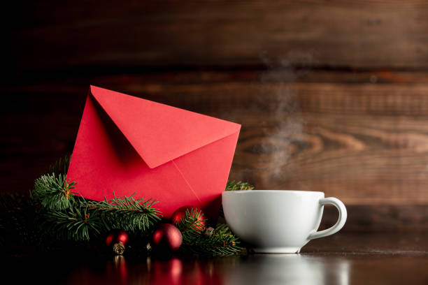 istock Cup of coffee and red envelope on wooden table 1192737437