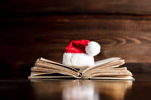 istock Old book and Christmas hat on wooden table 1192737498