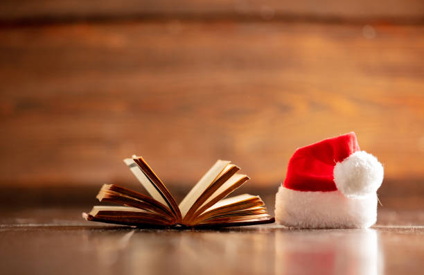 istock Christmas hat and open book on wooden table 1192737696