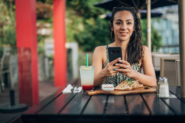 istock Beautiful woman sitting in restaurant and using phone 1192737892