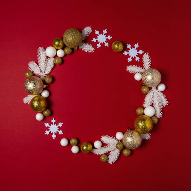 istock Christmas wreath with white pine tree branches and ball decoration on red backdrop. Creative copy space layout. Flat lay background. 1192741531