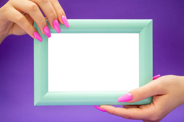 istock Female Hands with long Pink Nails holding Blank framed small Board 1192743716