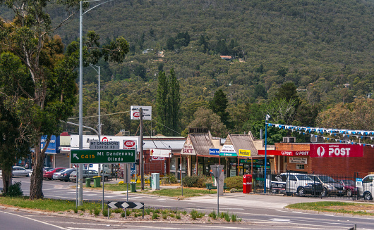 Melbourne, Australia - November 15, 2009: Outside city on road to Mount Dandenong, in Montrose community: local post office ansd small retail businesses with green forested flank of hill in back.