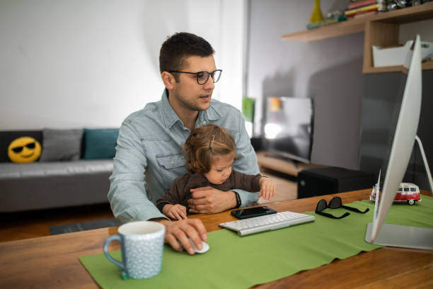 istock Young man working at computer with his daughter 1192748724