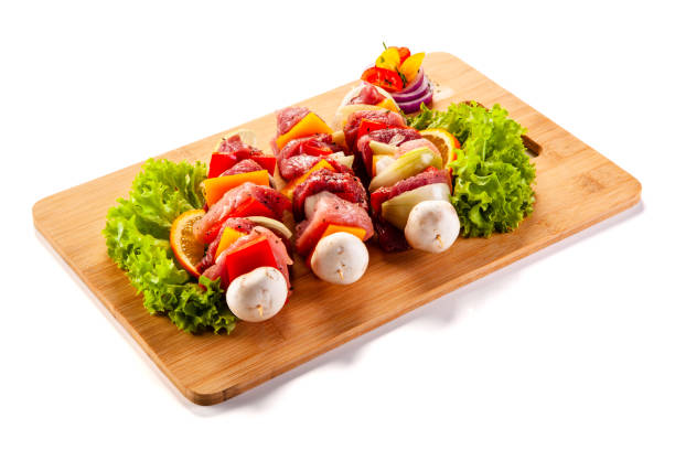 istock Raw shashliks on cutting board on white background 1192749005