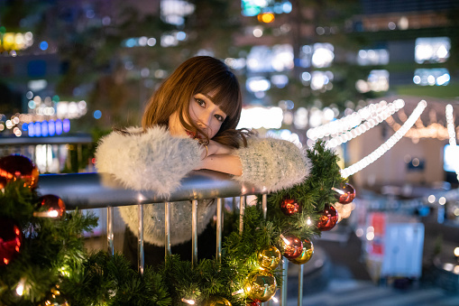 Portrait of beautiful woman in city at Christmas night