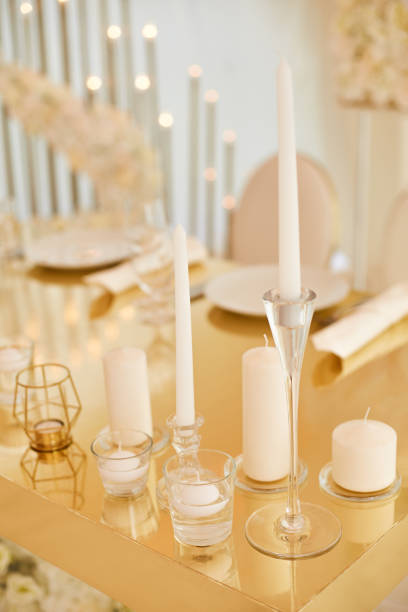 istock beautiful white candles in glass candlesticks on a gold-colored table 1192752511