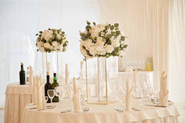 istock Dining tables during the wedding ceremony are decorated with a white tablecloth and bouquets of flowers in glass vases. 1192752517