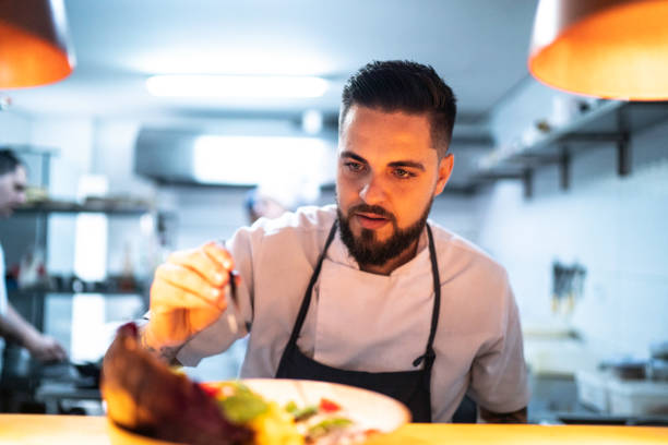 istock Kitchen chef using tweezers to finallize a dish 1192755052