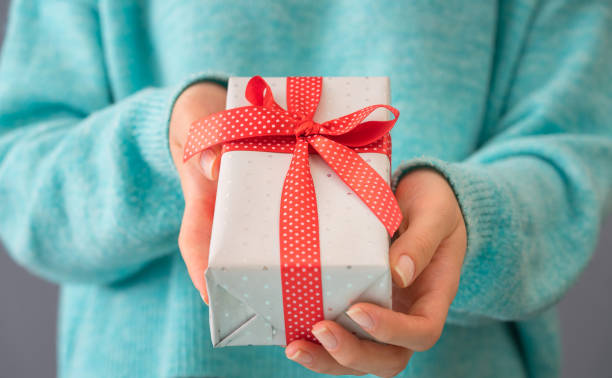 istock Woman hand holding gift package 1192758415