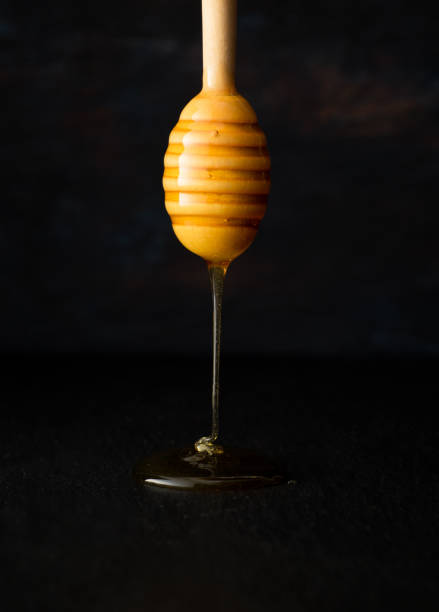 istock Wooden spoon with Honey on black ground 1192758447