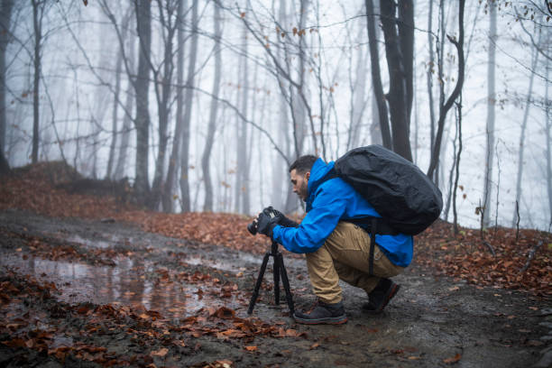 A young British boy dressed in business suit and tie looks through a homemade telescope at the top of a hill in Gloucestershire, United Kingdom. He is looking for new business opportunities and new ways to lead his business.