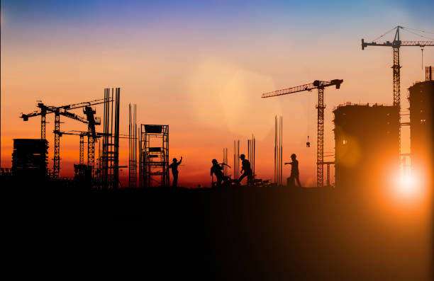 istock Silhouette of Survey Engineer and construction team working at site over blurred  industry background with Light fair Film Grain effect.Create from multiple reference images together 1192760480