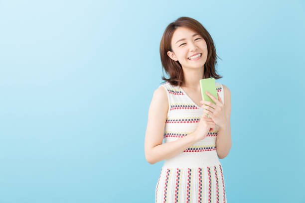 スマートフォンを見るアジアの女性 - スマホ 日本人 ストックフォトと画像
