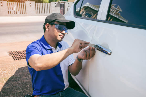 Young Man Opening White Car Door With Lockpicker. Young Man Opening White Car Door With Lockpicker. Professional making key in locksmith latch photos stock pictures, royalty-free photos & images